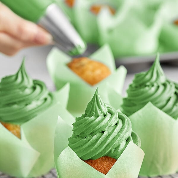 A close-up of green frosting on cupcakes made with Chefmaster Leaf Green food coloring.
