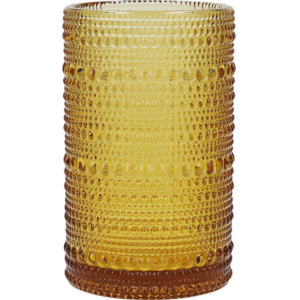 A close up of a Fortessa amber beverage glass with a textured pattern.