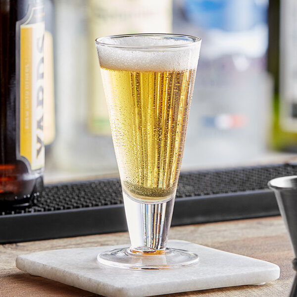 A Fortessa Tasterz mini pilsner beer glass filled with beer on a coaster.