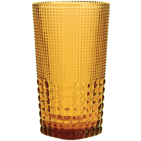 A close up of a Fortessa amber beverage glass with a patterned design.