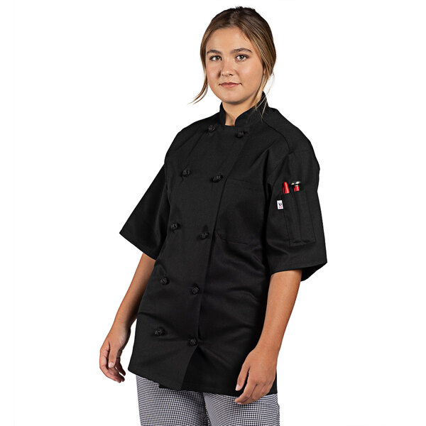 A woman wearing a black Uncommon Chef short sleeve chef coat.