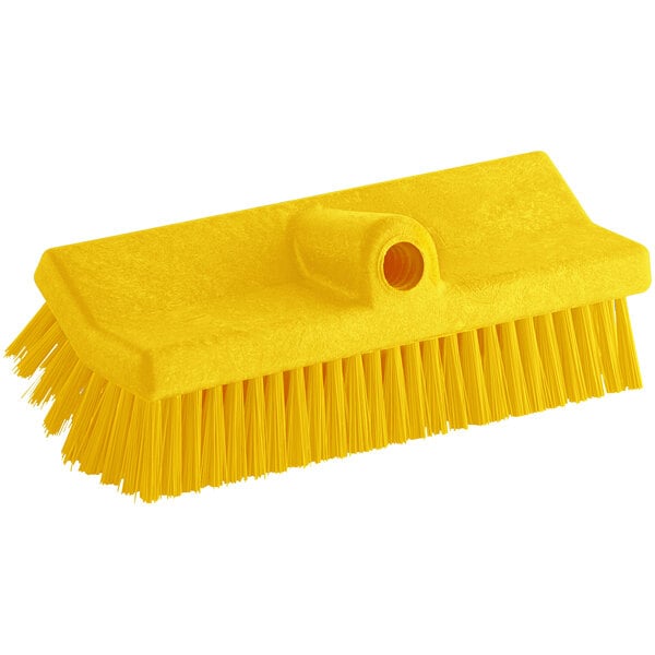 A Carlisle yellow floor scrub brush with a handle.