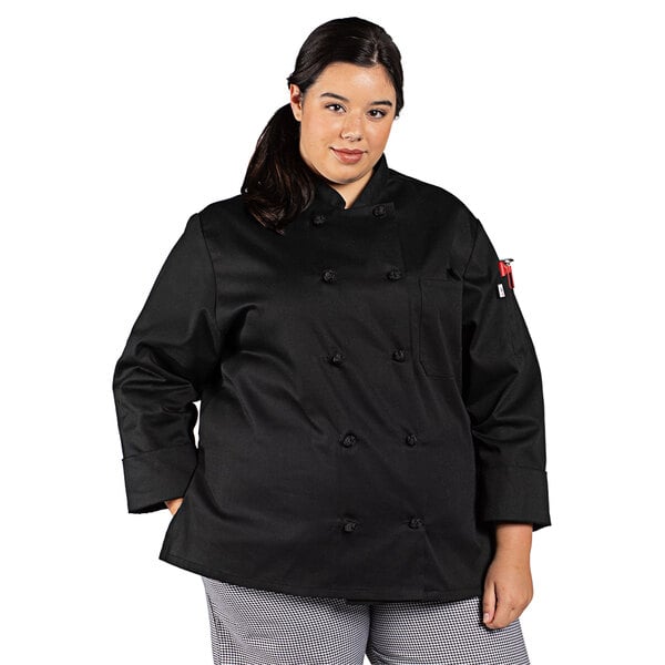 A woman wearing a black Uncommon Chef long sleeve chef coat.