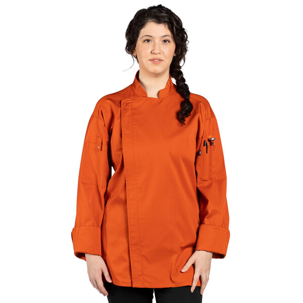 A woman wearing an orange Uncommon Chef long sleeve chef coat with a mesh back.