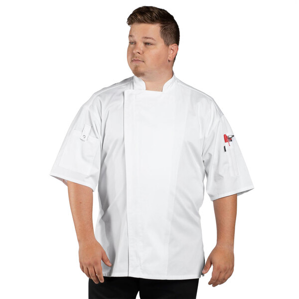A man wearing a white Uncommon Chef Venture Pro short sleeve chef coat with mesh back.