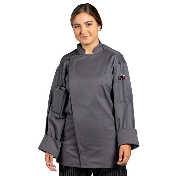 A woman wearing a slate grey Uncommon Chef long sleeve chef coat with a mesh back.