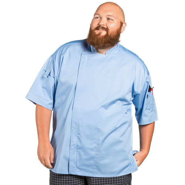 A man wearing a sky blue short sleeve chef coat with mesh back.