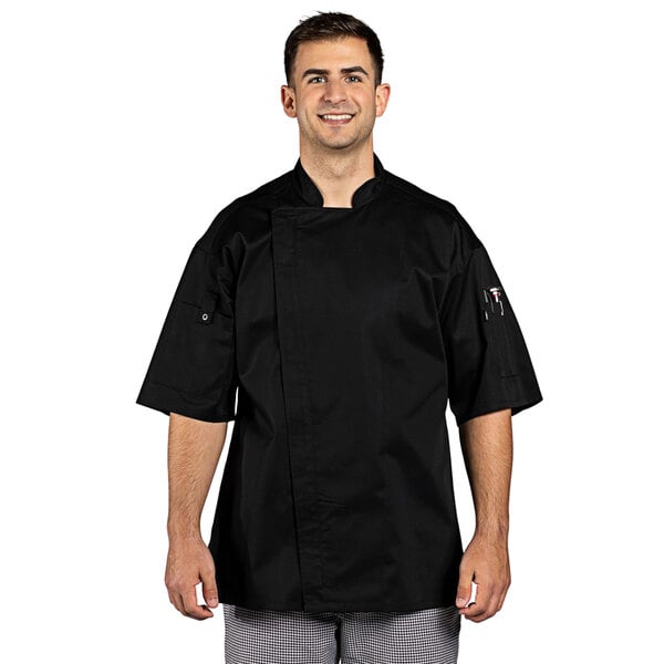 A man wearing a black Uncommon Chef Venture Pro chef coat.