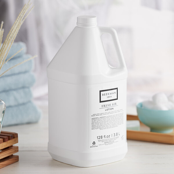 A white jug of Beekman 1802 Fresh Air body lotion on a table.