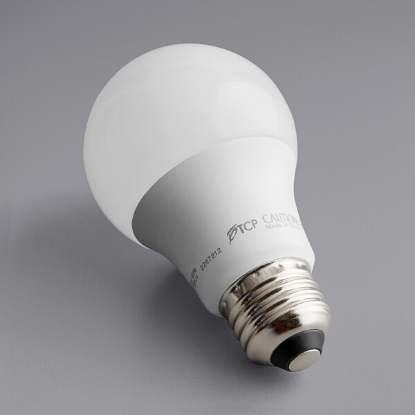 A TCP L60A19N1550K LED light bulb with a white base on a gray surface