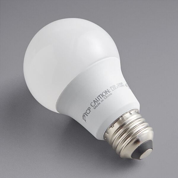 A TCP dimmable LED light bulb in packaging on a gray surface.
