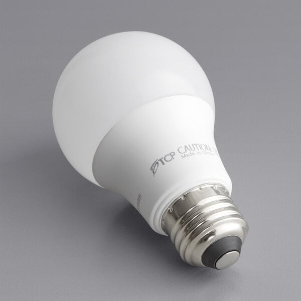 A TCP dimmable LED light bulb with a black and white logo and black rubber base.