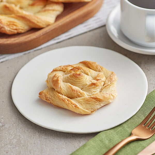 An Orange Bakery Danish snail pastry on a plate with a fork.