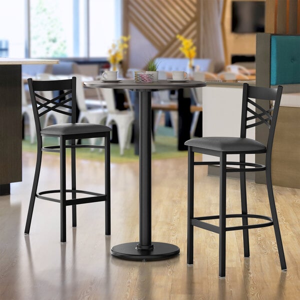 A white birch and ash bar table with a black base and chairs in a restaurant.