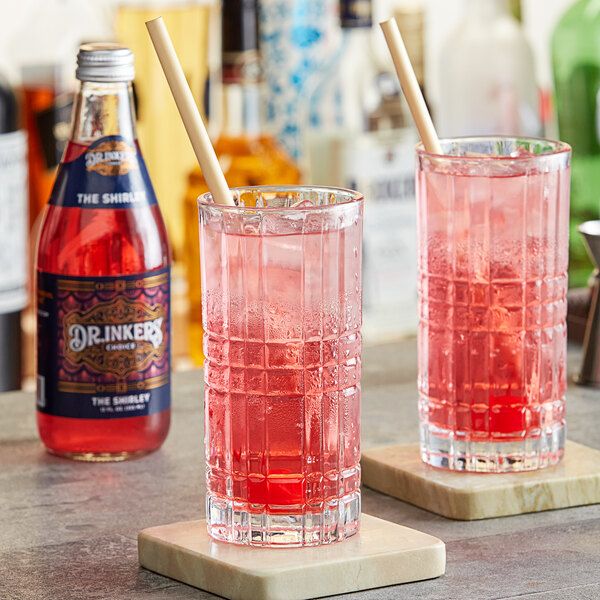 Two glasses of Dr. Inkers' Choice Shirley Temple soda with straws on a counter.
