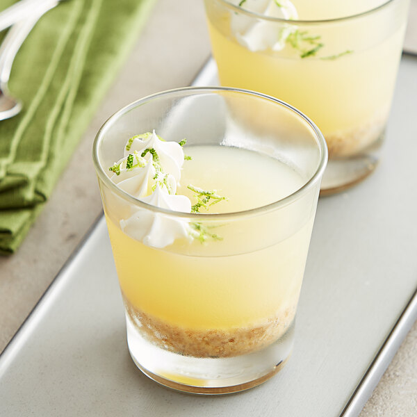 Two glasses of Les Vergers Boiron lime puree with whipped cream and lime garnish.