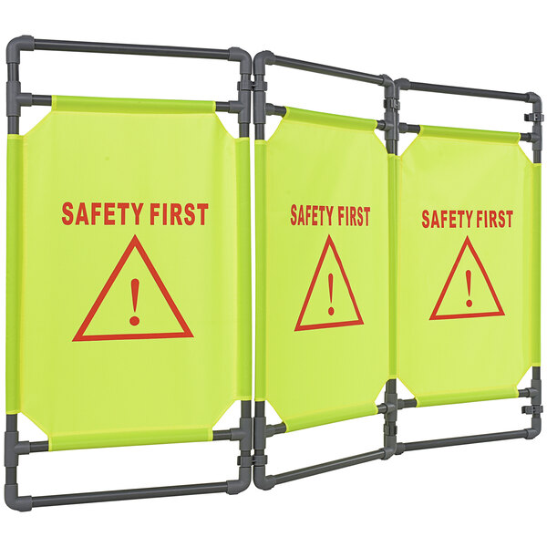 A yellow Vestil folding barrier with three "Safety First" signs in red.