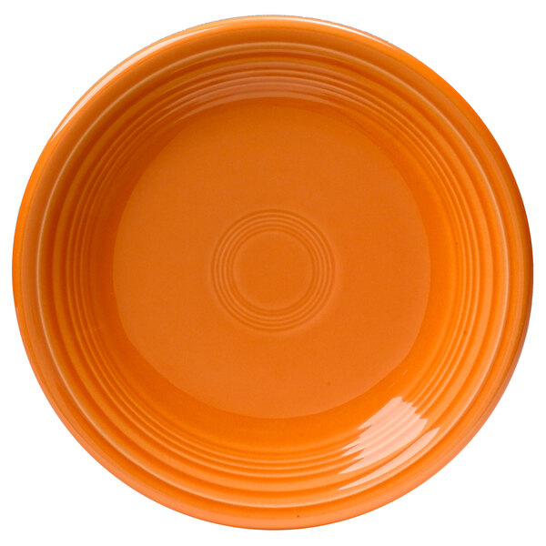 An orange Fiesta® salad plate with a circle pattern on the rim.