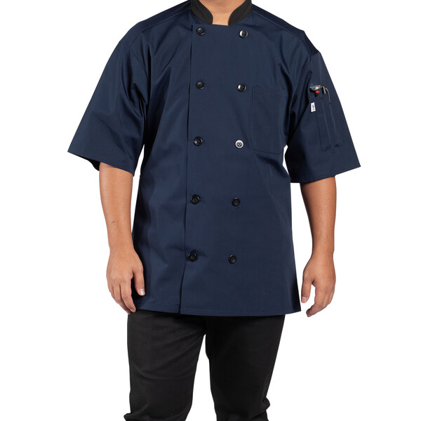 A man wearing a navy Uncommon Chef short sleeve chef coat with a mesh back.