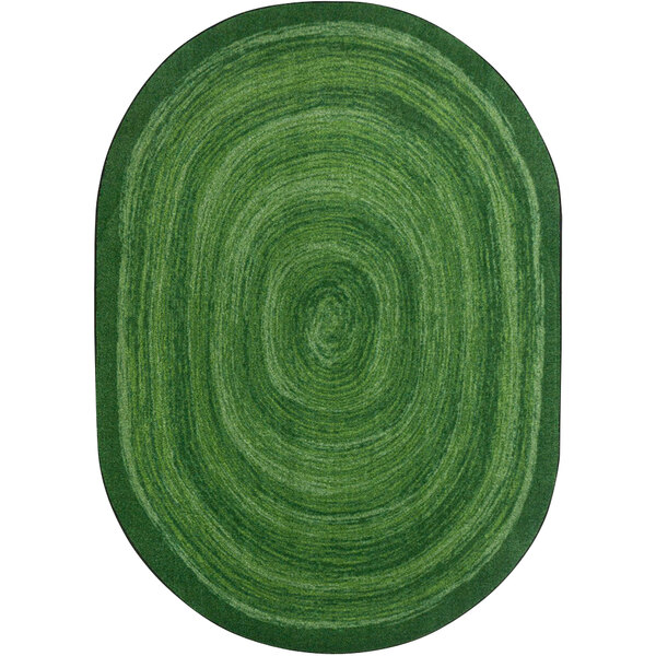 A green oval rug with a spiral pattern.