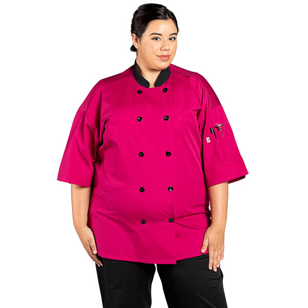 A woman wearing a pink Uncommon Chef short sleeve chef coat with a mesh back.