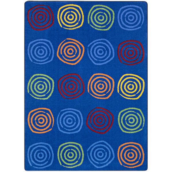 A blue rug with colorful circles on it.