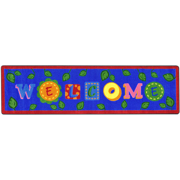 A blue rectangular rug with colorful leaves and letters on it.
