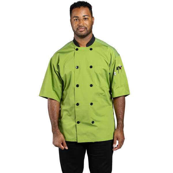 A man wearing a Uncommon Chef Havana green chef coat with black pants.