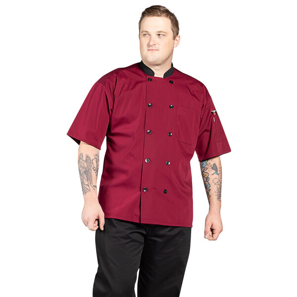 A man wearing a red Uncommon Chef short sleeve chef coat with a mesh back.