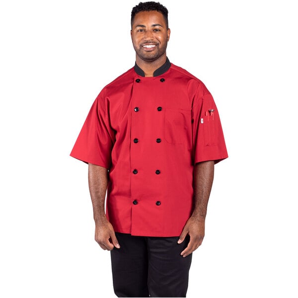 A man wearing a red Uncommon Chef coat in a professional kitchen.