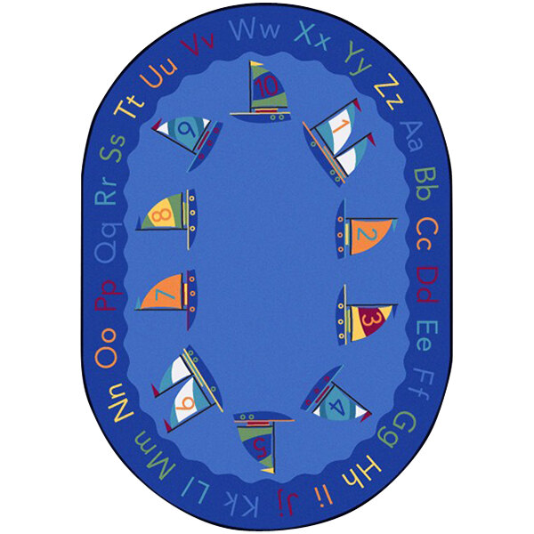 A blue oval rug with sailboats and letters in blue, orange, and green.