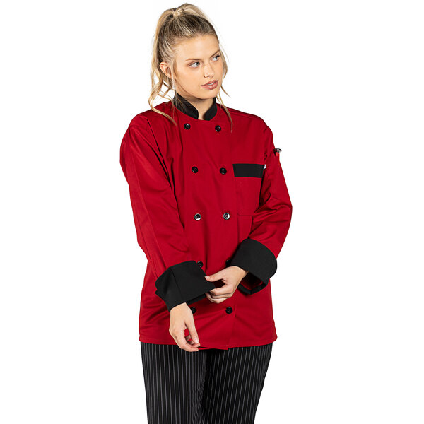 A woman wearing a red Uncommon Chef long sleeve chef coat with black trim.