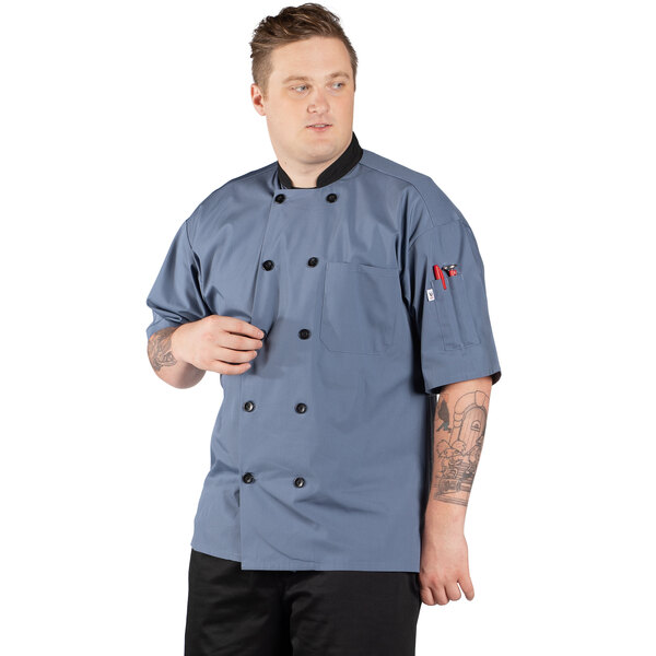 A man wearing an Uncommon Chef Havana short sleeve chef coat with mesh back.