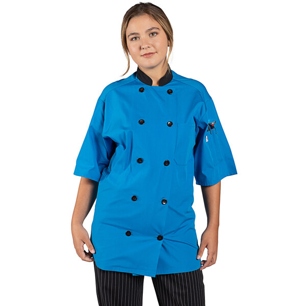 A woman wearing an Uncommon Chef cobalt blue short sleeve chef coat.