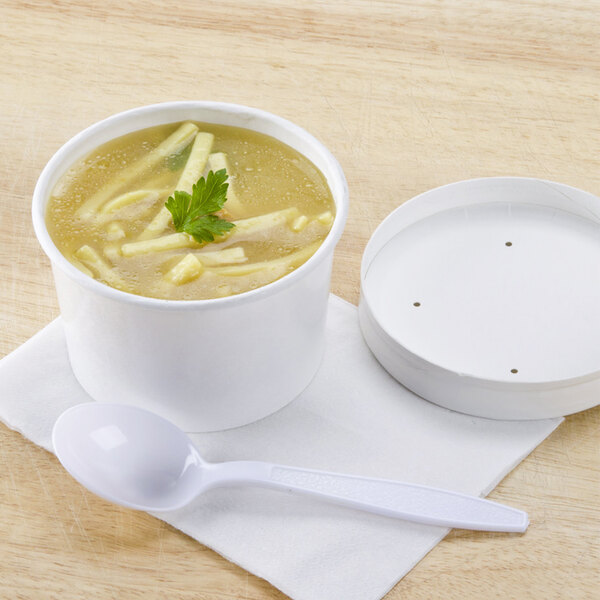 A white paper bowl of soup with a plastic lid on top.