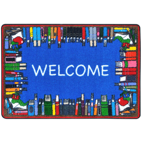 A multicolored rectangular area rug with a blue welcome sign and books on it.