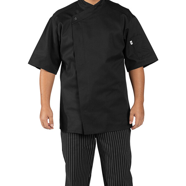 A man wearing a black Uncommon Chef Calypso Pro Vent chef coat.