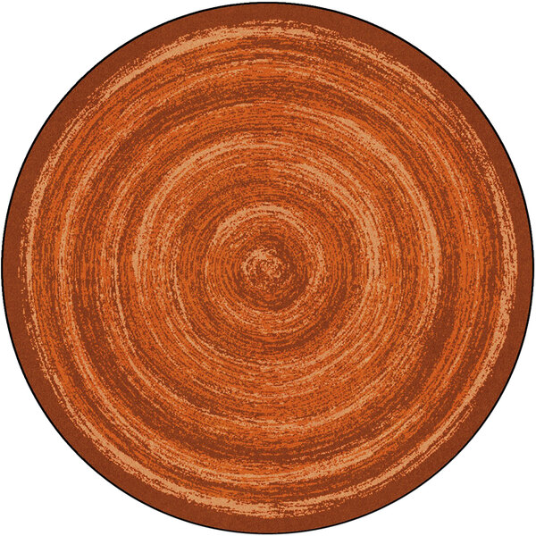 A Joy Carpets round area rug with a brown and orange spiral pattern.