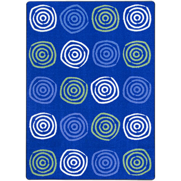 A blue rug with white and green circles and swirls on it.