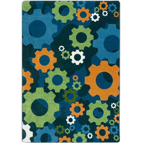 A Joy Carpets rectangular area rug with a colorful pattern of gears on a white and black background.