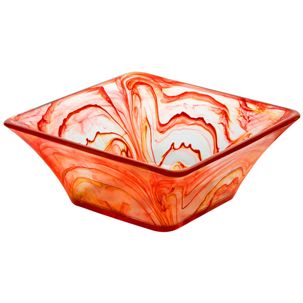 A square red and white swirl resin bowl on a counter.