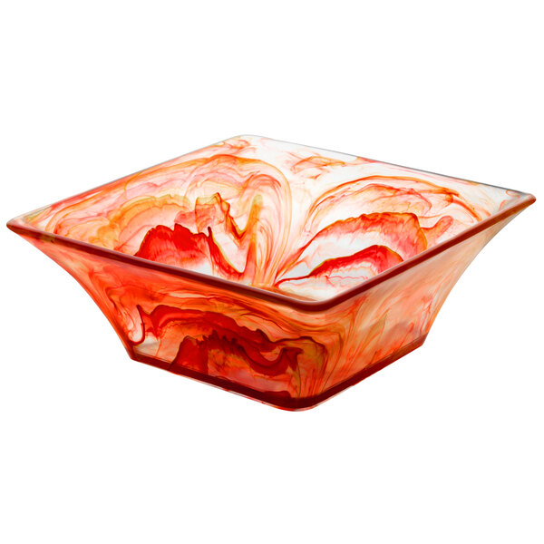 A square red resin bowl with white swirls on a counter.