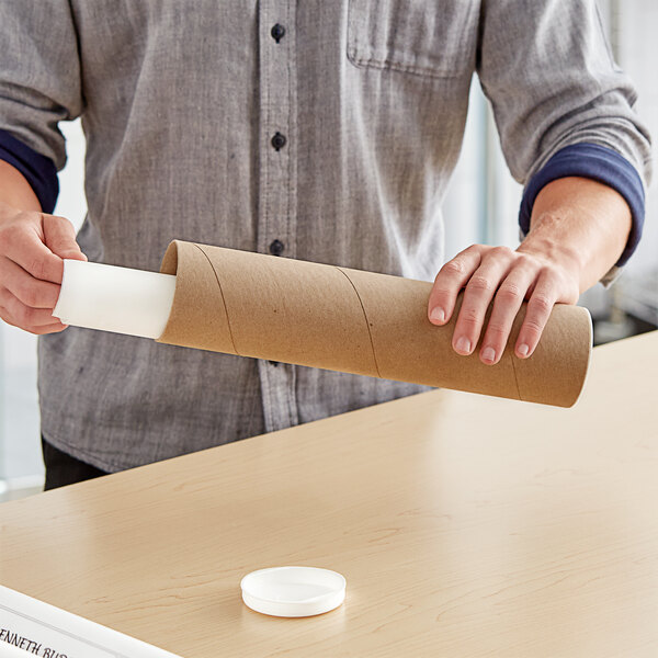 A hand holding a Lavex Kraft Mailing Tube