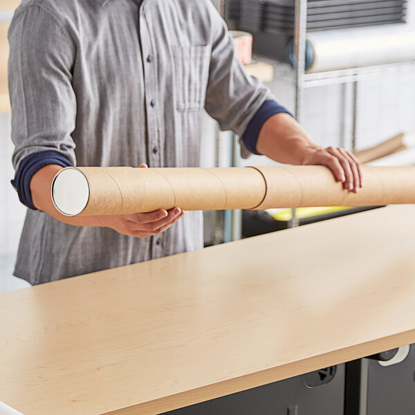 A person holding a long Lavex Kraft telescoping mailing tube.