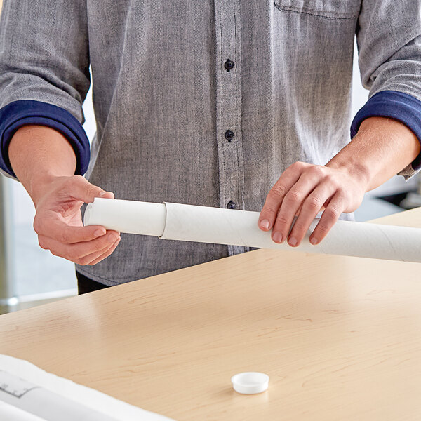 A person holding a white Lavex mailing tube filled with paper.