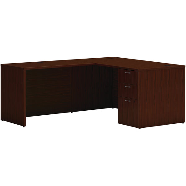 A brown traditional mahogany laminate L-station desk with drawers and a cabinet.
