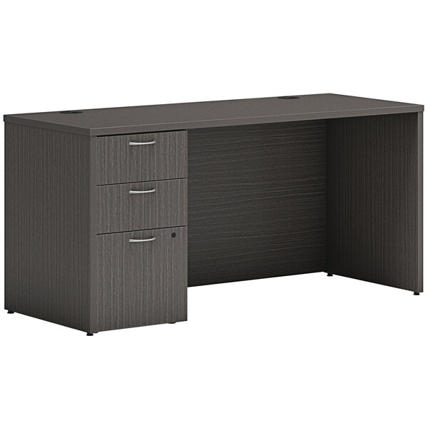 A dark gray Hon laminate desk with storage pedestal.