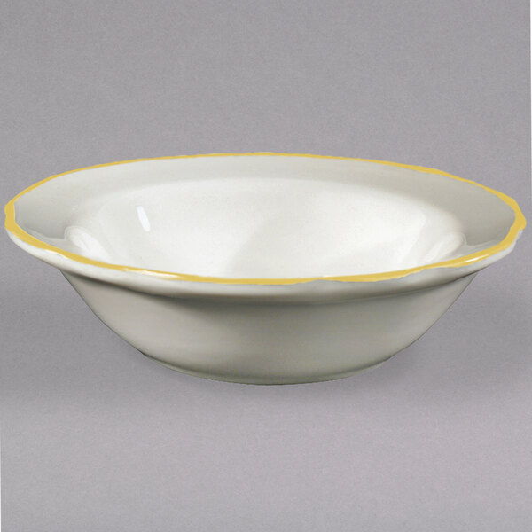 A CAC ivory china bowl with a yellow rim.