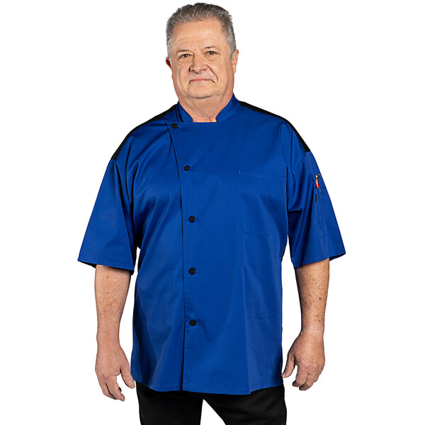A man wearing a royal blue Uncommon Chef short sleeve chef coat with a mesh back.