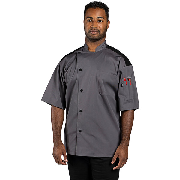 A man wearing a Uncommon Chef Rogue Pro Vent slate chef coat with mesh back.